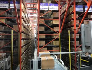 Packages stacked on warehouse shelves with organized labeling system.